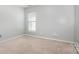 Bedroom with carpet flooring, light grey walls, and natural light from a window at 10901 Claude Freeman Dr, Charlotte, NC 28262