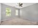 Neutral bedroom with two windows, ceiling fan, and neutral carpet offers a serene and bright living space at 10901 Claude Freeman Dr, Charlotte, NC 28262