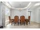 Elegant dining room showcasing a tray ceiling and gorgeous modern chandelier at 10901 Claude Freeman Dr, Charlotte, NC 28262