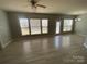 Spacious living room featuring hardwood floors, a ceiling fan and multiple windows at 10901 Claude Freeman Dr, Charlotte, NC 28262