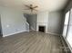 Bright living room with a fireplace, ceiling fan, and wood flooring at 10901 Claude Freeman Dr, Charlotte, NC 28262