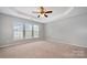 Spacious main bedroom with a tray ceiling, ceiling fan, and large windows with great natural light at 10901 Claude Freeman Dr, Charlotte, NC 28262