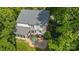 Aerial view of a home with a patio, fire pit, green lawn, and mature trees at 1108 Longwood Ct, Matthews, NC 28104