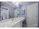 Bathroom featuring a blue painted wall, large mirror, and white cabinets at 1108 Longwood Ct, Matthews, NC 28104