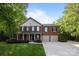 Charming two-story red brick home featuring a covered front porch, attached two-car garage, and well-manicured lawn at 1108 Longwood Ct, Matthews, NC 28104