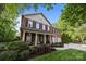 Beautiful brick home featuring a manicured lawn, black shutters, and a charming front porch with rocking chairs at 1108 Longwood Ct, Matthews, NC 28104