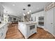Open-concept kitchen with white cabinets, granite counters, a large island, and stainless steel appliances at 1108 Longwood Ct, Matthews, NC 28104