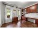 Bright office with custom shelving, hardwood floors, and large windows providing natural light and a view of the yard at 1108 Longwood Ct, Matthews, NC 28104