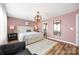 Cozy bedroom features a large bed with storage, an elegant light fixture, and a view into the bathroom at 1125 Jasmine Dr, Fort Mill, SC 29707