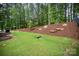 Lush backyard with a mulch hill and small creek, providing a serene backdrop for outdoor enjoyment at 113 Callandor Ct, Troutman, NC 28166