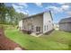 Spacious backyard with a well-maintained lawn, a patio area with outdoor seating, a grill, and green trees at 113 Callandor Ct, Troutman, NC 28166
