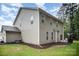 Exterior view of the rear of the home, featuring the siding, windows, and a concrete patio with a grill at 113 Callandor Ct, Troutman, NC 28166