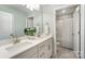 Bathroom with a double sink vanity, quartz countertop, ample mirror, and a shower behind an open door at 113 Callandor Ct, Troutman, NC 28166