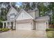 Beautiful home exterior with stone accents, vertical siding, and a spacious three-car garage at 113 Callandor Ct, Troutman, NC 28166