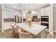 Bright kitchen features a large island with seating, stainless steel appliances, and gray backsplash at 113 Callandor Ct, Troutman, NC 28166