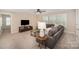 Living room featuring carpet, a comfortable sofa with throw pillows, a TV, and a bright sunny window at 113 Callandor Ct, Troutman, NC 28166