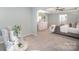 Well-lit main bedroom showcases a sitting area and dresser, perfect for relaxation and storage at 113 Callandor Ct, Troutman, NC 28166