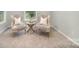 Cozy sitting area with matching upholstered chairs, a round accent table, and a sunlit window at 113 Callandor Ct, Troutman, NC 28166