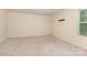 Spacious bedroom with neutral carpeting, a window with backyard views, and neutral colored walls at 1313 Forkhorn Dr, Monroe, NC 28110