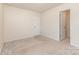 Simple bedroom with neutral walls, carpet, closet, and a door offering ample space ready for customization at 1313 Forkhorn Dr, Monroe, NC 28110