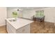 Bright modern kitchen island with stone countertop and a view of dining and living spaces at 1313 Forkhorn Dr, Monroe, NC 28110