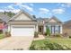 Charming home featuring a two-car garage, tidy lawn, and colorful landscaping, all beneath a bright blue sky at 2035 Moultrie Ct, Fort Mill, SC 29707