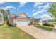 Charming home featuring a two-car garage, tidy lawn, and colorful landscaping on a sunny day at 2035 Moultrie Ct, Fort Mill, SC 29707