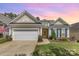Charming home featuring a two-car garage, tidy lawn, and colorful landscaping, all beneath a beautiful sunset sky at 2035 Moultrie Ct, Fort Mill, SC 29707