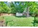 Spacious backyard featuring lush lawn, tall trees, and a white storage shed at 2124 Chambwood Dr, Charlotte, NC 28205