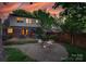 Backyard oasis featuring a patio, deck, mature trees, and cozy fire pit at 2124 Chambwood Dr, Charlotte, NC 28205