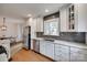 Updated kitchen boasting white cabinetry, stainless appliances, granite counters, and hardwood floors at 2124 Chambwood Dr, Charlotte, NC 28205