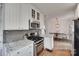 Kitchen with white cabinets, stainless steel appliances, gray backsplash, granite counters, and eat-in breakfast nook at 2124 Chambwood Dr, Charlotte, NC 28205