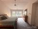 This primary bedroom features a ceiling fan, plush carpet, and natural light from the three windows at 2330 Winthorp Ridge Rd, Charlotte, NC 28270