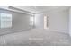 Large bedroom featuring neutral carpet, a tray ceiling, and natural light at 2522 Mabel Ln, Monroe, NC 28110