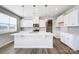 New kitchen boasts white cabinets, stainless appliances, stylish pendant lights, and a large center island at 2522 Mabel Ln, Monroe, NC 28110