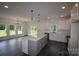 Open kitchen and living area with island, stainless steel appliances, and stylish pendant lighting at 3011 Buffett Ln # 33, Monroe, NC 28110