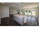 Spacious kitchen with island, stainless appliances, modern lighting, and views of the adjacent living area at 3011 Buffett Ln # 33, Monroe, NC 28110