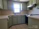 Cozy kitchen features abundant sage cabinets, stainless appliances, tile floors, and a bright window above the sink at 309 E 11Th St, Kannapolis, NC 28083