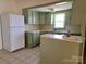 Cozy kitchen with green cabinetry, white appliances, and a convenient breakfast bar at 309 E 11Th St, Kannapolis, NC 28083
