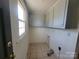 Utility room or laundry area with overhead cabinets, tile floor and a window at 309 E 11Th St, Kannapolis, NC 28083
