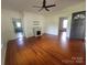 Open living room with hardwood floors, a fireplace, a ceiling fan, and access to other rooms at 309 E 11Th St, Kannapolis, NC 28083