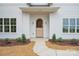 Charming wooden front door is framed by elegant sconces and manicured landscaping at 3622 E Brief Rd, Monroe, NC 28110
