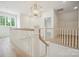 Bright hallway featuring wood floors, white wooden railings, and chandelier at 3622 E Brief Rd, Monroe, NC 28110