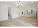 Bright, open-concept living space with modern lighting and seamlessly connected kitchen at 3622 E Brief Rd, Monroe, NC 28110