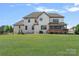 Expansive backyard view showcasing the home's white brick exterior and lush green lawn at 409 Wheatberry Hill Dr, Matthews, NC 28104