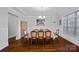 Formal dining room featuring wainscoting, elegant chandelier, and large windows, perfect for entertaining at 409 Wheatberry Hill Dr, Matthews, NC 28104