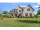 Stately brick home featuring a manicured lawn, attractive landscaping, and a covered front porch at 409 Wheatberry Hill Dr, Matthews, NC 28104