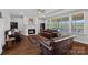 Cozy living room with a fireplace, hardwood floors, and large windows overlooking the backyard at 409 Wheatberry Hill Dr, Matthews, NC 28104