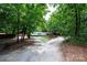 A single-story home featuring a manicured lawn, mature trees, and a gravel driveway at 475 Dot Faris Rd, Catawba, SC 29704