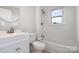 Bathroom with updated white vanity, toilet, and tub/shower combination with natural light at 506 7Th Sw St, Hickory, NC 28602